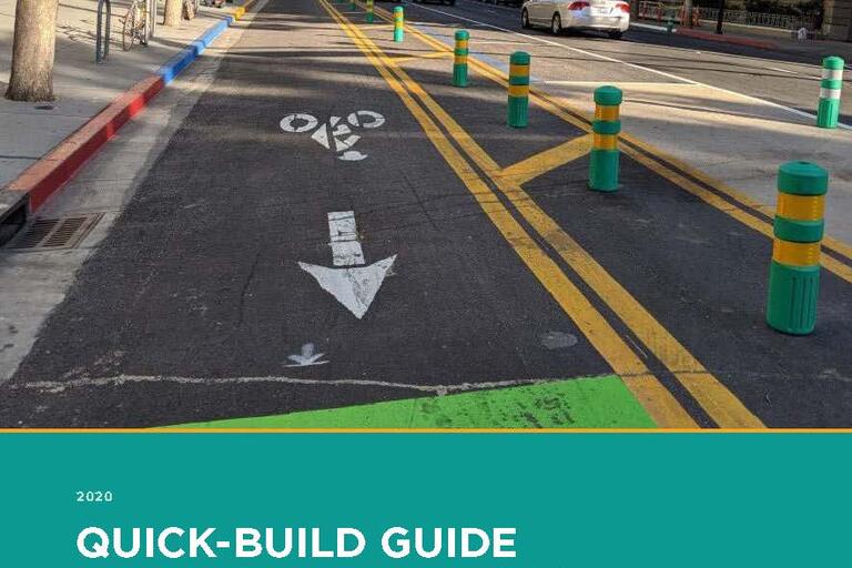 Cover of the Quick-Build Guide, showing a quick-build bike lane project with green soft-hit posts as barriers between the bike lane and cars