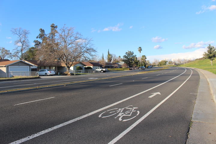 Painted bike lane on a four lane roadway next to a middle school.