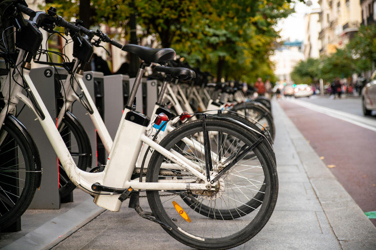 A row of e-bikes plugged into charging stations