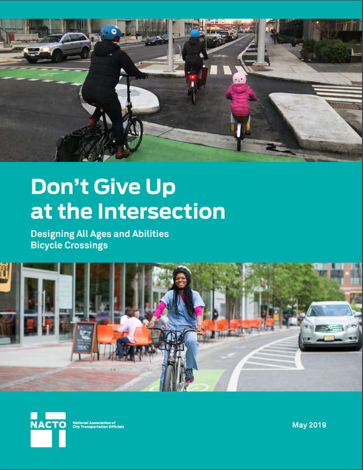 Image shows a family biking at a protected, separated intersection for bicyclists.