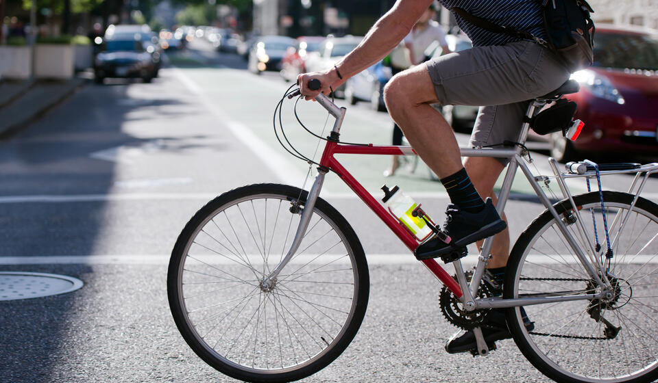 A person rides a bicycle across the street.