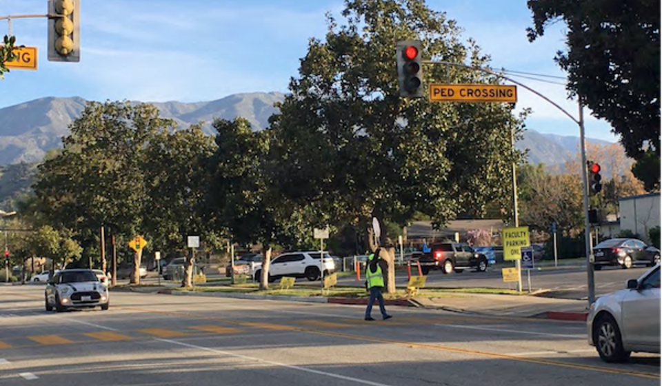 Crossing guard signaling for traffic to stop at an intersection in Claremont, CA