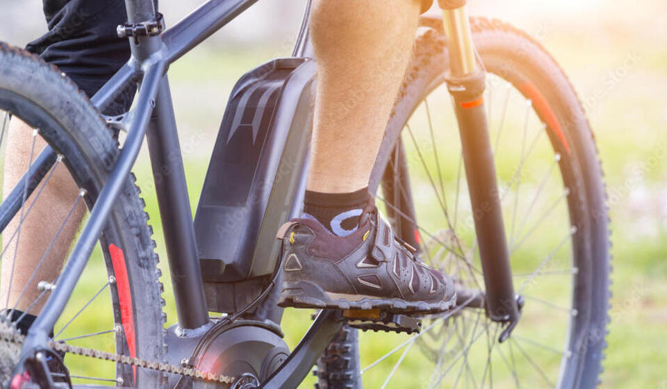 Close up of a person seen pedaling an e-bike