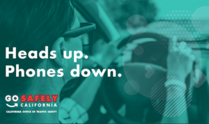 Pedestrian safety tip for drivers to have heads up and phones down with image of female driver with both hands on the wheel while driving