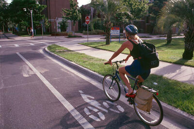 Woman bicycling in bike lane